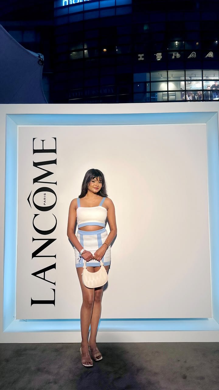 Vaishnavi Kadekar in a white and blue co-ord set in front of a Lancôme backdrop