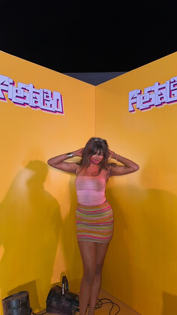 Vaishnavi Kadekar in a pink top and striped skirt at a yellow event photo booth